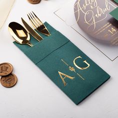 a place setting with gold and green napkins, silverware, and other personalized items