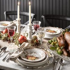 a table set for thanksgiving dinner with turkey and candles