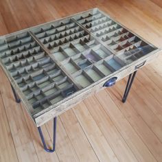 a glass table with metal legs on wooden flooring