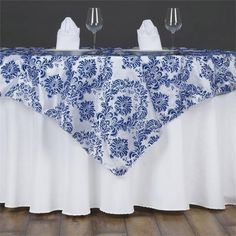 two wine glasses are sitting on top of a table with a blue and white cloth