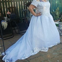 a woman in a white dress standing on a patio with her hands on her hips