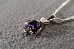 I am offering you this truly exquisite vintage unique genuine combination round and oval shaped prong set African amethyst and cultured pearl stones done in a dimensional curved scrolled design shaped , on a necklace chain. What a spectacular design.... So very elegant and a very fancy ornate setting. It is measuring a bit under 1 inch by app. 1/2 inch, you will be noticed when wearing this lavaliere necklace. The necklace chain is a very sturdy rolled rope link chain that measures a very versat Dainty Oval Purple Jewelry, Oval Purple Birthstone Jewelry, Dainty Purple Oval Jewelry, Purple Amethyst Jewelry With Pearl Pendant, Antique Purple Oval Necklaces, Classic Amethyst Oval Pendant Jewelry, Vintage Purple Oval Pendant Necklace, Purple Amethyst Oval Pendant Necklace, Luxury Purple Pearl Necklace, Elegant