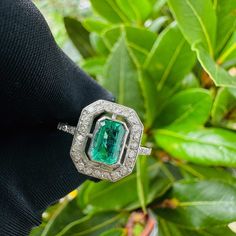 A stunning Art Deco style, Emerald and diamond ring, featuring an Emerald, mounted in a collet setting, surrounded with a row of twenty-two, eight cut diamonds, all beautifully made in Platinum with diamond mounted shoulders terminating to a slender shank. The Emerald is a beautiful green coloured gemstone, it is an emerald-cut and measures 6.5 x 4.7mm with an estimated carat weight of 0.65cts The diamonds are eight-cuts, they are bright and clean with an estimated combined carat weight of 0.28c Art Deco Diamond Emerald Ring With Brilliant Cut, Art Deco Diamond Ring With Gemstone, Art Deco Emerald Ring With Diamond Center Stone, Art Deco Emerald Diamond Ring With Accents, Art Deco Emerald Ring With Baguette-cut Diamond, Art Deco Emerald Ring With Baguette Cut Center Stone, Art Deco Emerald Ring With Baguette Diamond, Formal Octagon Emerald Ring With Diamond, Octagon Emerald Ring With Diamond Accents