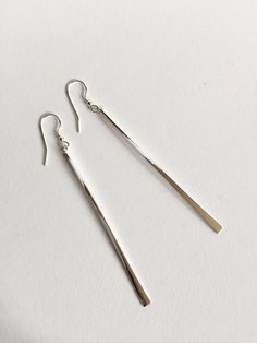 Elegant, simple long drop earrings, hand forged from solid sterling silver 925 wire. They dangle beautifully and look stunning as they catch the light when they move, as they are highly polished with a mirror finish. There are 2 pairs of these little beauties left in stock! I use square wire 2mm wide. Approx 65mm long. Sterling silver earwire fittings. Weight approx 3g. Each one is hand forged, so no two will be exactly the same, and there will be differences in the appearance of the metal which Long Bar Earrings, Long Drop Earrings, Long Dangle Earrings, Earrings Long, Bar Earrings, Earrings Statement, Hand Forged, Long Earrings, Statement Earrings