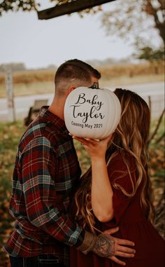 a man and woman kissing in front of a sign that says baby tyler coming may 2012