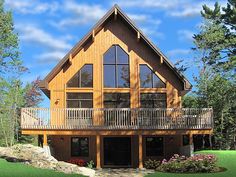 a large wooden house sitting on top of a lush green field