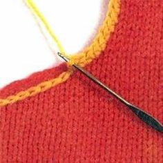 an orange sweater with yellow stitching and a pair of scissors