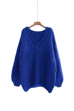 a blue sweater hanging on a wooden hanger