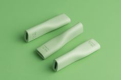 three white grips sitting on top of a green surface