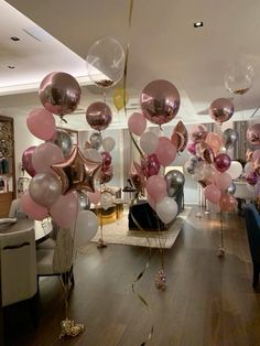 balloons and streamers are hanging from the ceiling in an elegant room with wood flooring