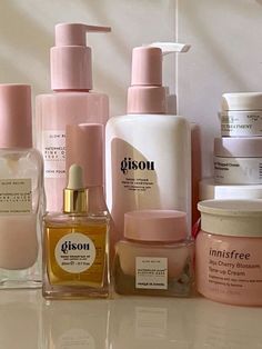 many different types of skin care products on a counter top with white walls behind them