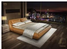 a large bed sitting on top of a wooden floor next to a night sky view