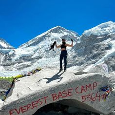 a woman standing on top of a large rock