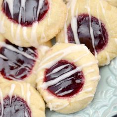 raspberry thumbprint cookies on a plate with white icing