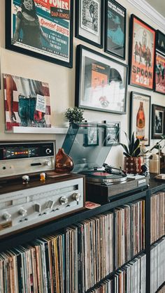 a record player is sitting on top of a shelf in front of many records and cds