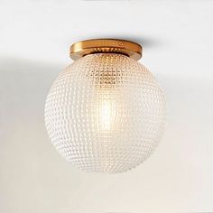 a light that is hanging from the ceiling in a room with white walls and flooring