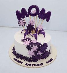 a white cake with purple flowers on top