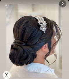 a woman is wearing a hair comb with flowers in it's bun hairstyle