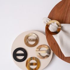 three pieces of wood sitting on top of a white table next to a wooden plate