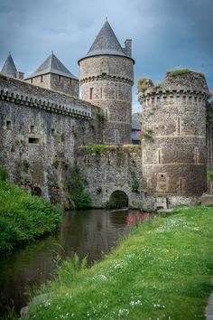 an old castle sitting next to a river