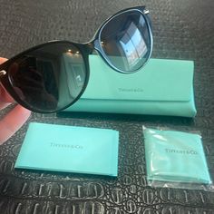 Tiffany & Co Sunglasses Black & Blue With T On Side Comes With Original Tiffany & Co Case New Dust Tiffany Rag Booklet Included Frame Color: 8055t3 Black On Tiffany Blue Lens Color: Polar Grey Gradient Polarized Lens: Yes Lens Material: Plastic Prescription Capable: Yes Frame Shape: Cat Eye Frame Material: Plastic Frame Type: Full Rim Gender: Women's Lens Width: 57 Bridge Width: 16 Arm Length: 140 Lens Height: 49 Brand New Never Worn - Nwt Elegant Blue Sunglasses For Formal Occasions, Trendy Blue Sunglasses For Formal Occasions, Elegant Blue Sunglasses For Evening, Chic Blue Sunglasses For Formal Occasions, Blue Sunglasses With Uv Protection For Formal Occasions, Designer Blue Sunglasses For Formal Occasions, Elegant Travel Sunglasses With Mirrored Lenses, Elegant Mirrored Sunglasses For Travel, Formal Blue Sunglasses With Uv Protection