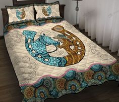 a bed covered in a blue and white bedspread with an animal on it