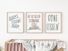 three framed posters on the wall above a crib with a baby's bed