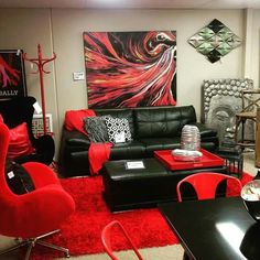 a living room filled with black furniture and red rugs