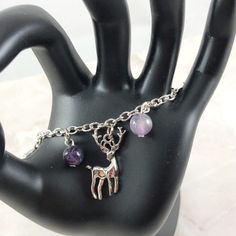 This fun charm bracelet is the perfect accessory to showcase your love for Artemis, Greek goddess of the hunt and the moon. Charms included: Moon Bow and Arrow Bear Stag Tree 5 genuine gemstone beads are placed in between each charm. Your choice between amethyst or moonstone. Comes in three sizes: Small: 6.5 inches (with extra rings at the end to expand up to 7.5 inches.) Standard: 7.5 inches Large: 8.5 inches Ships in a jewelry box so it's ready to be give as a gift. Amethyst helps you to tap i Mystical Jewelry Bracelet Gift, Mystical Gemstone Bracelets As Gift, Mystical Bracelets With Natural Stones As Gifts, Mystical Natural Stone Bracelets As Gift, Mystical Jewelry With Round Beads As Gift, Metal Crystal Bracelet With Gemstone For Gift, Silver Charm Bracelet With Gemstone Beads As Gift, Silver Charm Bracelet With Natural Stones For Gift, Metal Crystal Bracelet With Charms As Gift