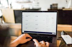 a person sitting at a table using a laptop computer