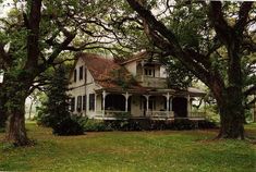 an old house surrounded by trees and grass