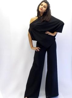 Women party jumpsuit made of jersey and chiffon. Asymmetrical sleeveless jumpsuit with large pants and asymmetrical top. Jumpsuit is made of two pieces: pants on elastic belt and asymmetrical blouse that is caught sideways hidden staple Black beads lateral sleeve closure. Elegant black jumpsuit. Material: 50% cotton, 50% polyester Care instructions: Wash at 30 degrees The model in the picture is size S. Can be made in ALL SIZES. If you have any other specific requirements, do not hesitate to con Asymmetric Jumpsuit, High Low Lace Dress, Cocktail Summer, Cocktail Party Outfit, Party Jumpsuit, Womens Black Jumpsuit, Large Pants, Two Piece Jumpsuit, High Waist Wide Leg Pants