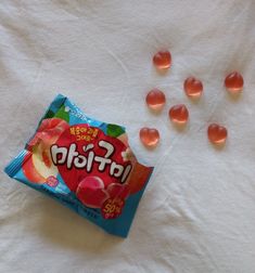 a bag of fruit flavored candy sitting on top of a white towel next to small candies