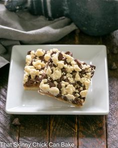 two pieces of chocolate and marshmallow bars on a white plate