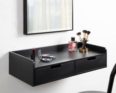 a black desk with two drawers and a mirror on the wall above it, along with other items