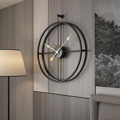 a clock mounted to the side of a wall next to a night stand and lamp