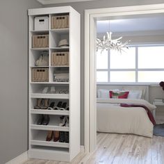 an open door leading to a bedroom with white furniture