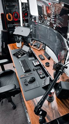 a computer desk topped with lots of computers and other electronics on top of a wooden table