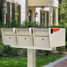 three mailboxes in front of a white house