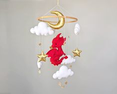 a baby crib mobile with a red dragon and stars hanging from it