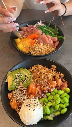 two black plates filled with different types of food