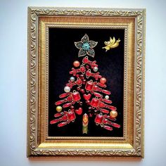 a christmas tree made out of beads and other items in a gold frame on a wall