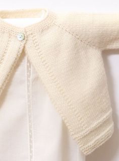 a close up of a white sweater on a hanger