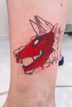 a close up of a person's foot with a red dragon tattoo on it