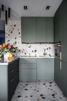 a kitchen with green cabinets and floral wallpaper on the backsplash is shown