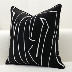 a black and white pillow sitting on top of a couch