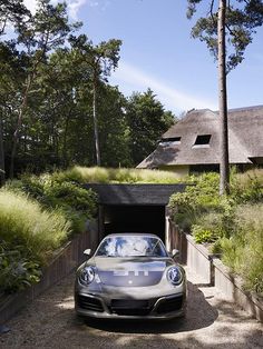 a car is parked in front of a house with grass growing on it's roof