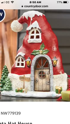 a red and white santa hat house sitting on top of a table