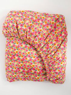 a pink and yellow flowered comforter on a white background