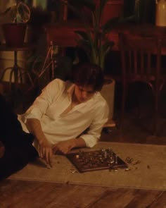 a woman sitting on the floor playing with a board game